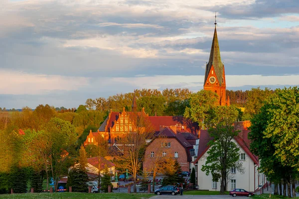 Gietrzwald - Polonya 'nın Warmia ve Mazury bölgesinde bir köy - bahar manzarası, çiçek açan kolza tohumu. Kutsanmış Bakire Meryem 'in Doğumu Bazilikası Gietrzwald' da.