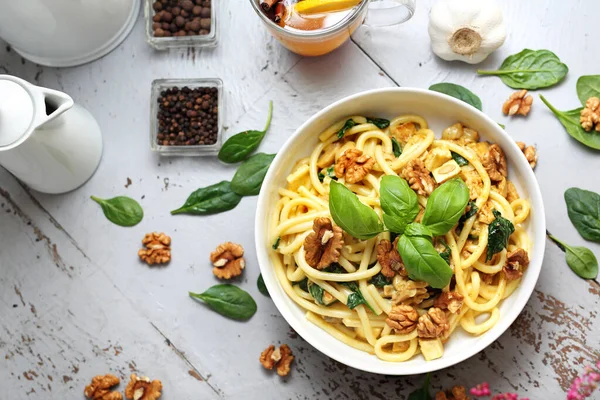 Bucatini de macarrão em molho creme com espinafre fresco, nozes de alho — Fotografia de Stock