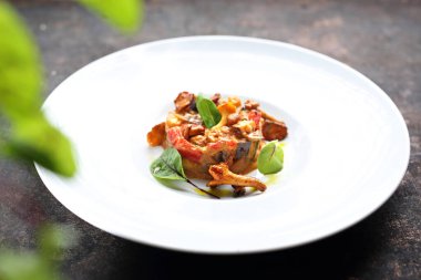 Beyaz bir tabakta servis edilen sebze ve yumurta ile pişirilmiş Chanterelle mantarları..