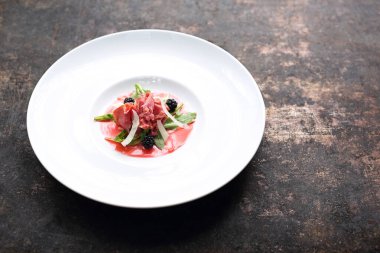 Ahududu ve böğürtlenli kremayla servis edilen sığır carpaccio. Aperatif