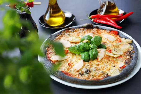 Pizza negra, sabrosa pizza sobre masa negra . — Foto de Stock