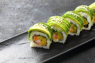 Suşi. Geleneksel Japon suşisi. Beyaz arka planda siyah bir tabakta iştah açıcı.