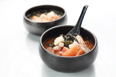  Japon çorbası. Somon balıklı balık çorbası, yengeç çubuğu ve yosun. Geleneksel Japon mutfağı. Doğu mutfağı. Beyaz arkaplanda tabak