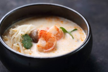 Tom yum, Hindistan cevizi sütü, karides ve mantarlı baharatlı çorba. Geleneksel Japon mutfağı. Doğu mutfağı. Koyu arkaplanda çorba