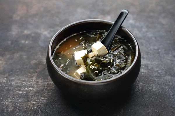 Miso Ramen. Vejetaryen tofu çorbası, alg ve pastayla birlikte. Geleneksel Japon mutfağı. Koyu bir arka planda yemek. Beyaz bir arka planda yemek..