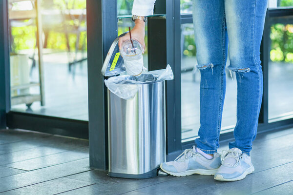 Close Up hand throwing empty litter in recycling bin.Throwing plastic into recycle bin.Waste separation rubbish before drop to garbage bin to save the world,Pollution trash recycling management concept.