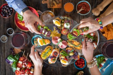 Lokantada ellerini masaya koyan ve insanlara bir sürü tapas ikram eden bir adam.
