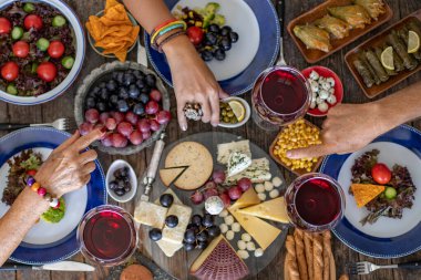 Kırmızı şarap ve tezahüratla bir kutlama için aile yemeği. Bir aile yemeğinin üst görünümü (beraberlik)
