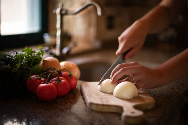 重点放在用洋葱和西红柿在种植板上准备食物的女手上 粮食作物种植概念 — 图库照片