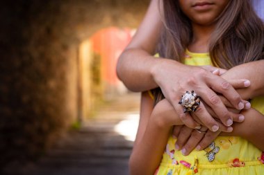 Anneler Günü 'nde el ele tutuşan bir anne ve kızın yakın çekimi. İtalya sokaklarında anneler günü konsepti.