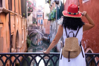 Kırmızı şapkalı bir turist Venedik Kanallarına bakıyor. İtalya, Venedik 'te tatil kavramı.