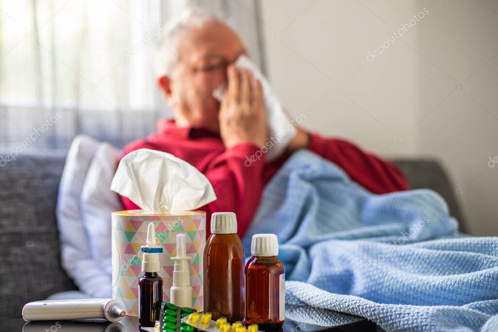 A senior flu man is lying on the bed with fever , illness concept at the bedroom with bed and blanket