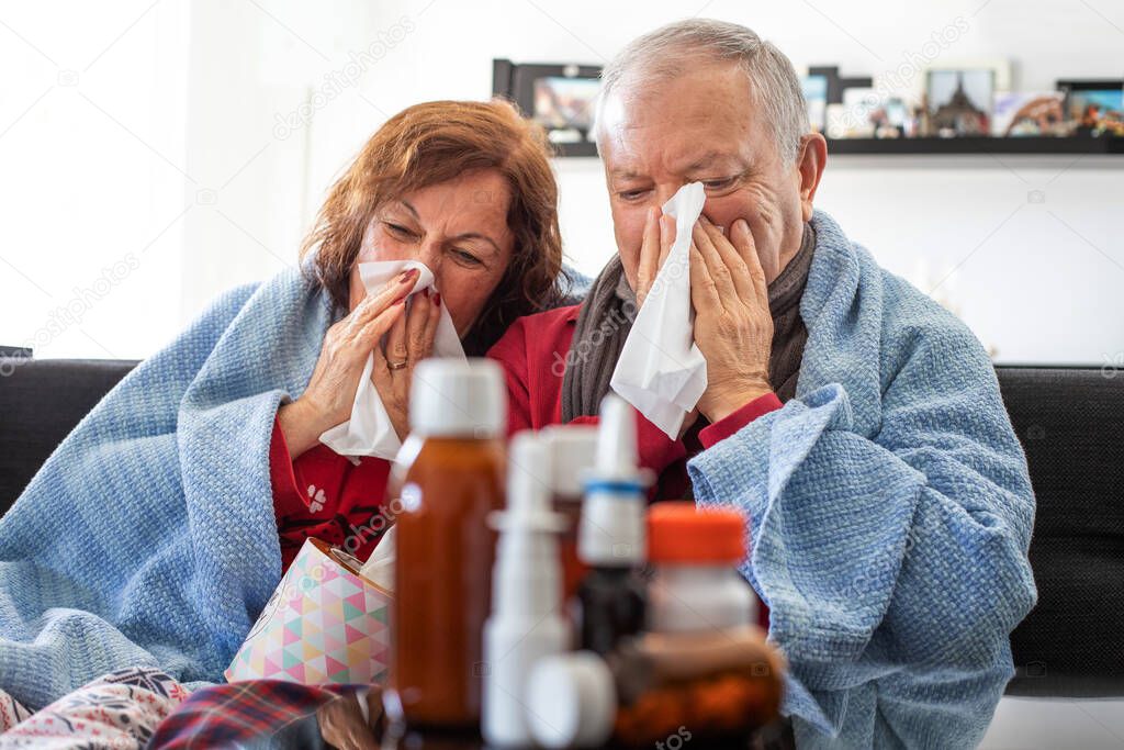 Elderly man lying on the bed and blow his nose ,  flu concept with pills and syrups
