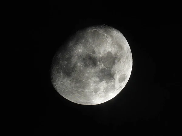 На ночном небе стоит яркая трехчетвертая луна — стоковое фото