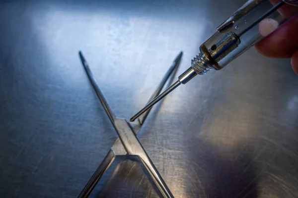 Ledningen till ett kirurgiskt instrument oljas med en oljespruta. — Stockfoto