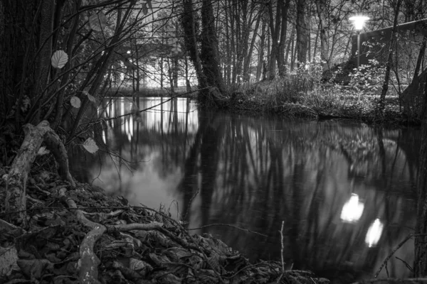 A black and white photograph of a river landscape in the darknes — Stock Photo, Image