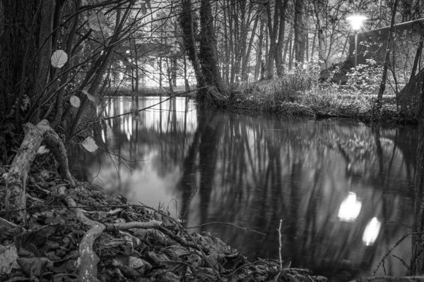 Eine Schwarz-Weiß-Fotografie einer Flusslandschaft in der Dunkelheit — Stockfoto