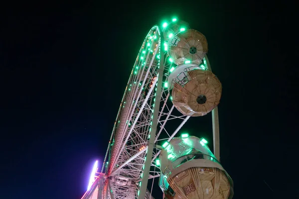 夜空には巨大な観覧車のカルーセルが輝き — ストック写真