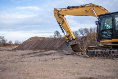 Büyük kürekli bir kazıcı koca bir toprak dağını yerinden söker.