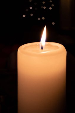  Beyaz yanan mum koyu bir arkaplan önünde duruyor 
