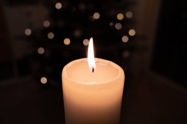  Beyaz yanan mum koyu bir arkaplan önünde duruyor 