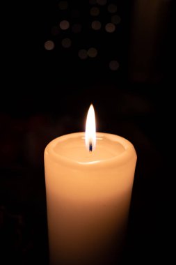  Beyaz yanan mum koyu bir arkaplan önünde duruyor 