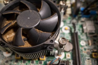 Bir bilgisayarın içindeki çok kirli bir bilgisayar vantilatörü bir boşluk tarafından temizlenir.