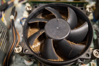 Bir bilgisayarın içindeki çok kirli bir bilgisayar vantilatörü bir boşluk tarafından temizlenir.