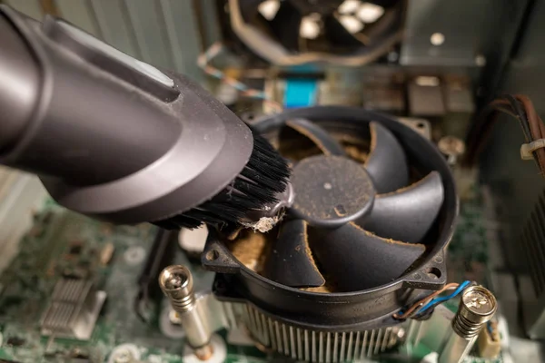 Um ventilador de computador muito sujo dentro de um computador é limpo por um vacu — Fotografia de Stock