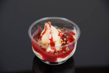 a sundae with vanilla ice cream and sauce on a dark base