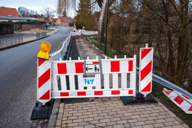 Bir sokakta kaldırım yırtılmış ve toprak kazılmış.