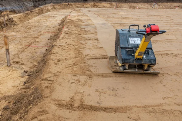 Un sitio de construcción hay un vibrador preparando el terreno para fou —  Fotos de Stock