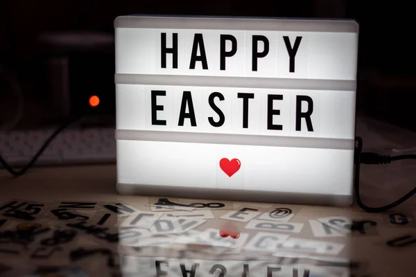 a white illuminated cinema sign with black letters Happy Easter