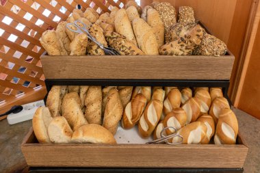 Kahvaltı büfesinde iki sepet dolusu farklı ekmek var.