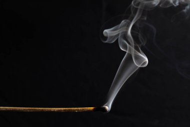 Yanmış kibrit hala siyah arkaplanda sigara içiyor 