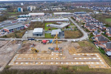 Bir fabrika binasının sütunlarının beton temelinin atıldığı büyük bir inşaat alanının insansız hava aracı görüntüleri
