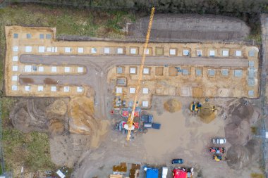 Bir fabrika binasının sütunlarının beton temelinin atıldığı büyük bir inşaat alanının insansız hava aracı görüntüleri