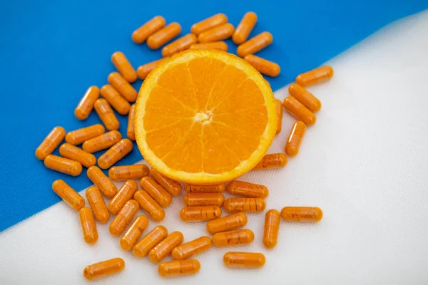 Cut Open Orange Stands Several Orange Pills White Blue Background — Stock Photo, Image