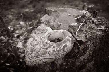 Mezarlık zemininde kilden bir kalp bir ağaç kütüğüne bağlı.