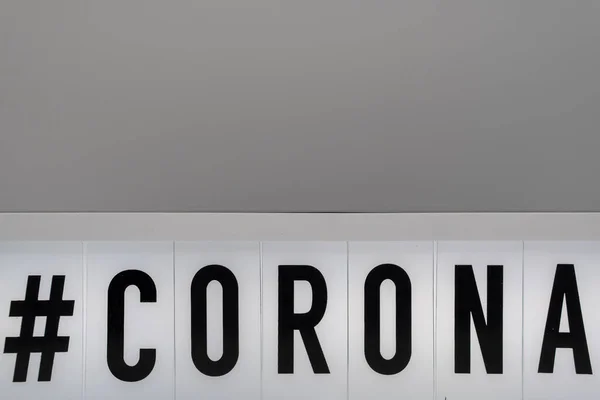 a light box with the inscription: #CORONA with grey background