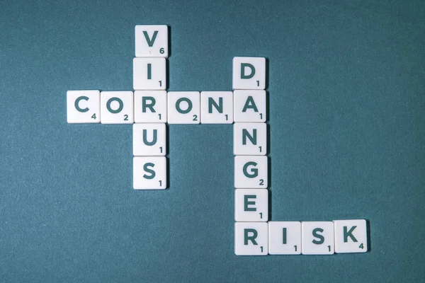 在绿色的基础上有一些游戏片段 上面有字母 它们形成了单词 Corona Virus Danger Risk — 图库照片