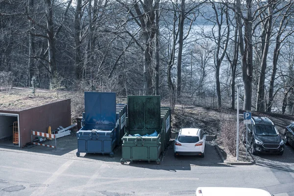 in the yard of a hospital, two waste compactors stand side by side