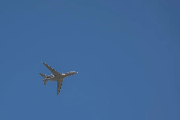 Mały Biały Samolot Odrzutowy Leci Niebieskim Prawie Bezchmurnym Niebie — Zdjęcie stockowe