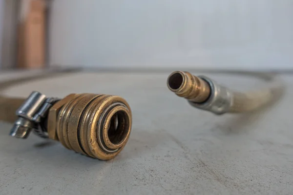 a compressed air hose with coupling is lying on the floor of a workshop