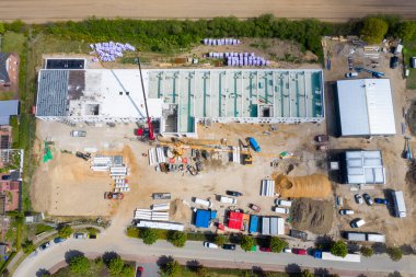 Büyük bir fabrika binasının inşa edildiği büyük bir inşaat alanının insansız hava aracı fotoğrafı.