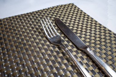 Çatal bıçak takımı bir restoranın yüzeyinde yatıyor.