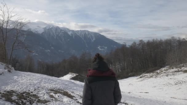Πάνω από τον ώμο ενός κοριτσιού που περπατούσε προς μια καλύβα το χειμώνα. — Αρχείο Βίντεο