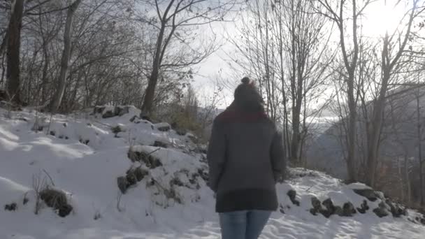 Over de schouder van een meisje met uitzicht op de bergen in de winter — Stockvideo