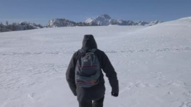 Kar tarlasında yürüyen bir yürüyüşçünün yörünge görüntüsü.