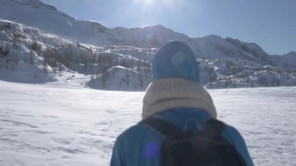 強風で雪の中を歩く少女の後に撮影追跡 — ストック動画